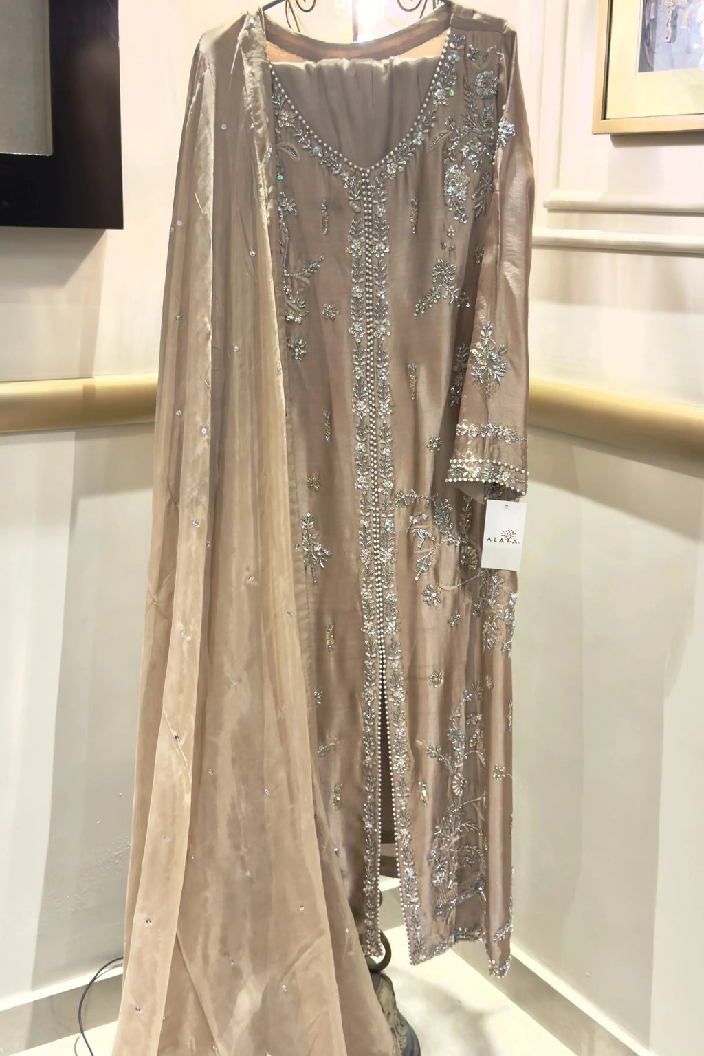 Elegant dress with sequin detailing on a mannequin against a neutral background