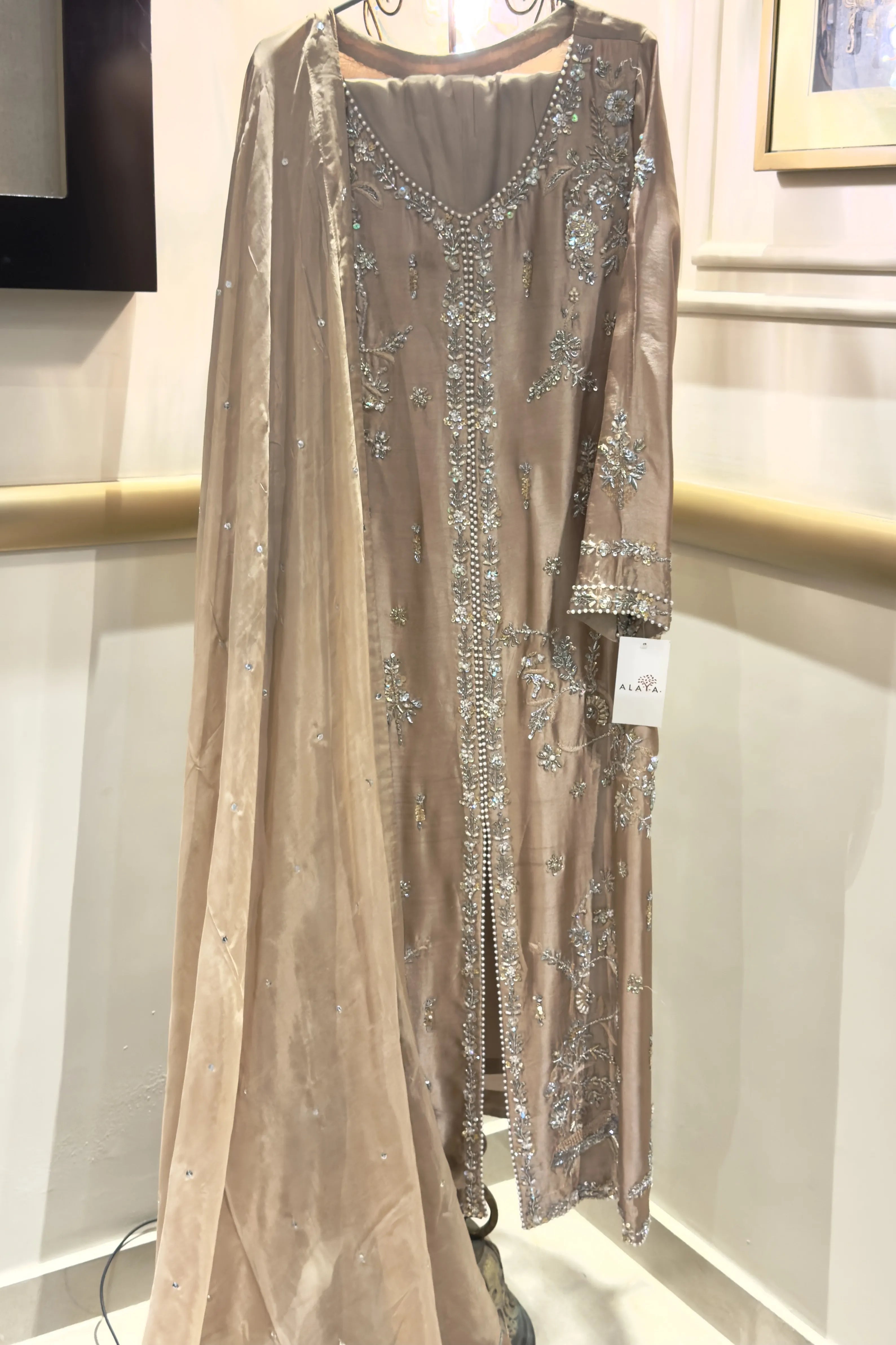 Elegant dress with sequin detailing on a mannequin against a neutral background