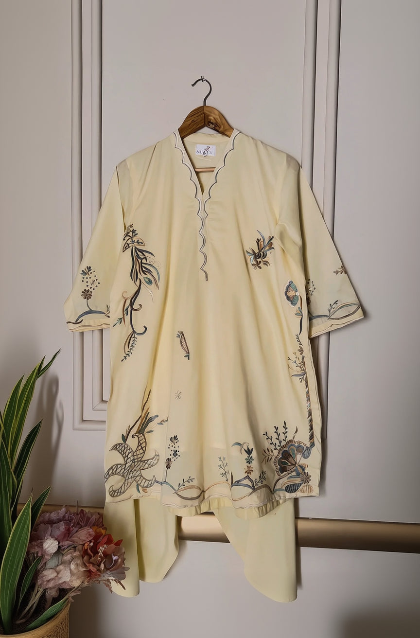 Beige embroidered kurta with pants on a hanger against a neutral background